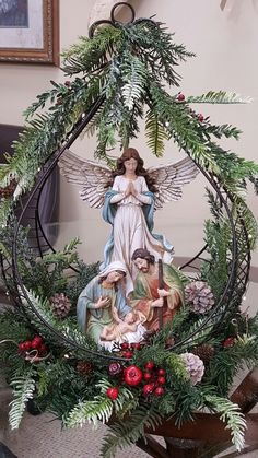 a christmas wreath with angel figurines and greenery