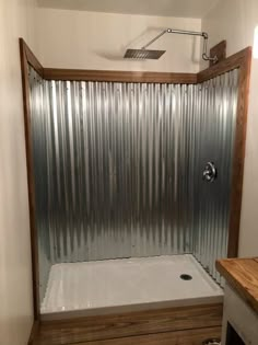 a bathroom with a shower and wooden counter top