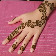 a woman's hand with henna on top of it and flowers painted on the palm