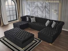 a living room filled with black couches and pillows