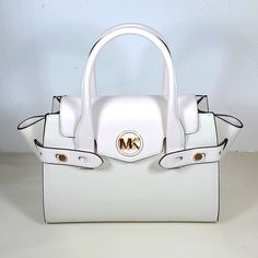 Carmen Medium Faux Leather Belted Satchel Optic White Satchel Faux Leather 88.92% Coated Canvas/11.08% Polyester Gold-Tone Hardware 11"W X 7.75"H X 5"D Handle Drop: 4.75” Exterior Details: Detachable Crossbody Strap Interior Details: Back And Front Slip Pockets Lining: 100% Polyester Push-Lock Fastening White Leather Satchel With Gold-tone Hardware, Designer White Satchel With Gold-tone Hardware, White Leather Luxury Satchel, Luxury White Leather Satchel, White Leather Satchel, Michael Kors Top Handle Satchel With Detachable Handle, Michael Kors White Shoulder Bag With Detachable Strap, Michael Kors Leather Top Handle Satchel, White Michael Kors Shoulder Bag With Detachable Strap