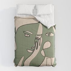 a green and white comforter with two faces on it