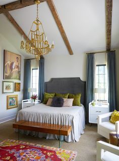 a bedroom with a large bed and chandelier hanging from the ceiling