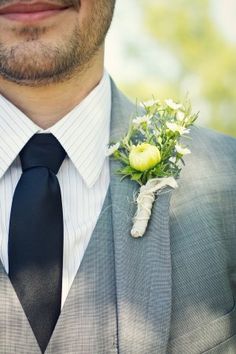 a man wearing a suit and tie with a boutonniere on his lapel