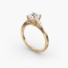 a yellow gold engagement ring with three stones on the side and two diamonds in the center