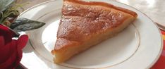 a piece of pie sitting on top of a white plate next to a red rose