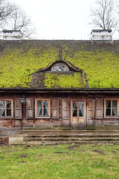 an old building with moss growing on the roof