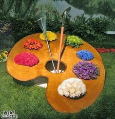 a wooden table with different colored flowers on it