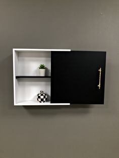 a black and white shelf with two shelves on each side that has a plant in it