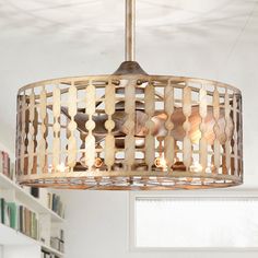 a chandelier hanging from the ceiling in a room with bookshelves behind it