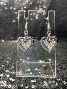 Black and silver heart earrings with rhinestones filling the center. Heart-shaped Rhinestone Earrings For Valentine's Day, Silver Heart Earrings With Rhinestones For Gift, Silver Open Heart Earrings For Party, Silver Heart Earrings With Rhinestones For Party, Silver Double Heart Earrings For Party, Double Heart Rhinestone Jewelry For Party, Silver Dangle Heart Earrings For Party, Silver Double Heart Earrings For Valentine's Day, Elegant Heart-shaped Rhinestone Earrings