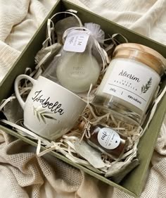 two mugs in a box with labels on them, one containing honey and the other containing soap