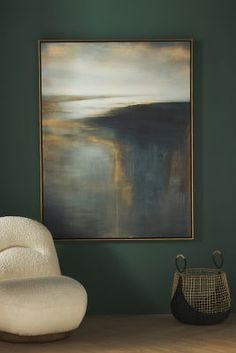 an abstract painting hangs on the wall next to a chair and vase in front of it