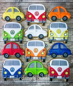 cookies decorated like vw bug's are arranged on a wooden table for display