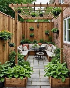 an outdoor patio with potted plants on the side and a table in the middle