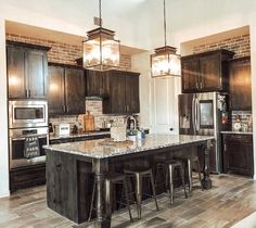 a large kitchen with an island in the middle and two stools at the end