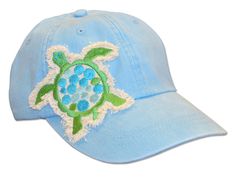 a light blue hat with a green turtle embroidered on the front and side, sitting against a white background