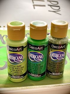 three bottles of acrylic paint sitting on a shelf