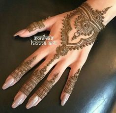 a henna tattoo is on the palm of a woman's hand