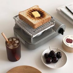 a toaster sitting on top of a counter next to a plate with some fruit