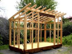 a wooden structure sitting in the middle of a field