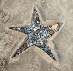 a star made out of rocks on the beach