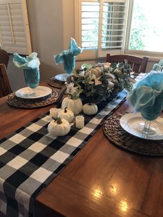 the table is set for thanksgiving dinner with blue and white decorations on top of it