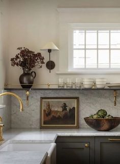 a kitchen with marble counter tops and gold faucets on the wall above it