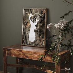 a deer head mounted to the side of a wooden table next to a vase with flowers