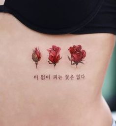 a woman's stomach with three red roses on it and the words written in chinese