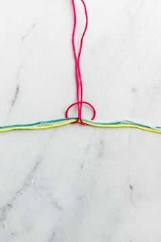 a pair of scissors and yarn on a marble counter top, with the cord still attached