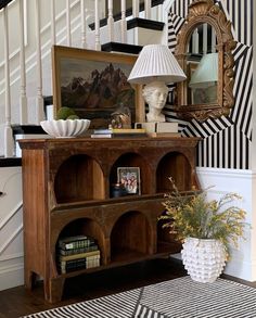 there is a vase with flowers in it on the table next to some bookshelves