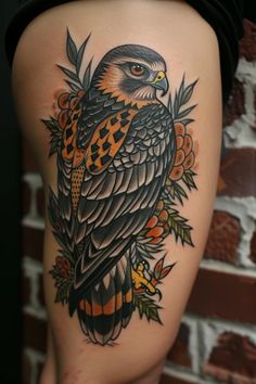 an owl tattoo on the back of a woman's thigh, with flowers around it