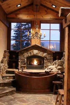 a fireplace in the middle of a room with stone steps and a large bathtub