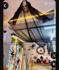 a room decorated for halloween with decorations on the ceiling