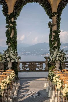 an outdoor ceremony set up with white flowers and candles