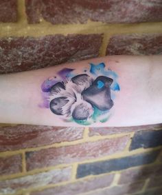 a tattoo on the arm of a person with two mushrooms and blue watercolors