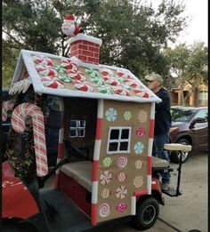 a man standing next to a small house made out of candy canes