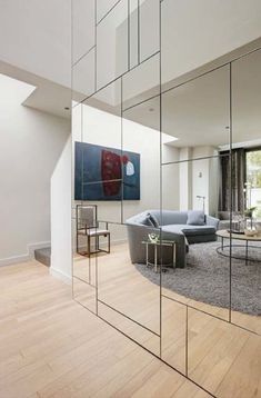 a living room filled with furniture next to a large mirror on top of a wall