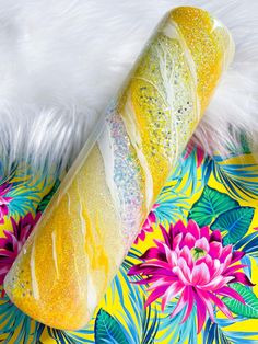 a yellow pastry with white frosting and sprinkles sitting on a colorful background