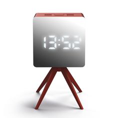 an alarm clock sitting on top of a wooden tripod with the time 11 30