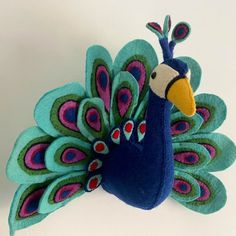 a stuffed toy peacock with colorful feathers on it's back