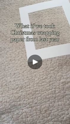 a white box sitting on top of a bed next to a carpeted floor with the words, what if we took christmas wrapping paper from last year?