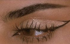 a woman's eye with long lashes and glitters on her eyeshade