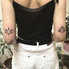 a woman with two small tattoos on her arms