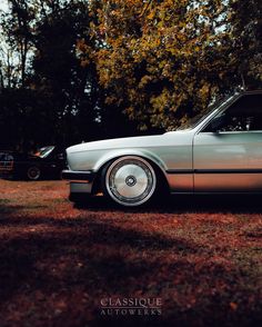 an old car is parked in the grass