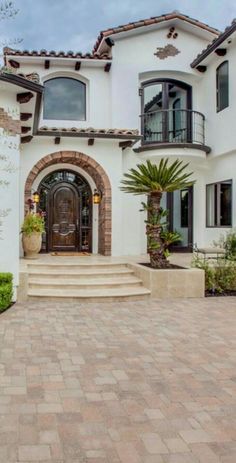 a large white house with steps leading up to the front door and entryway area