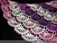 a crocheted doily with purple and white flowers in the shape of leaves