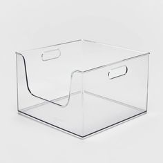 a clear plastic storage box with handles on the front and bottom, sitting on a white surface