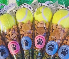 four tennis balls are wrapped in plastic bags with dog paw prints on the top and bottom